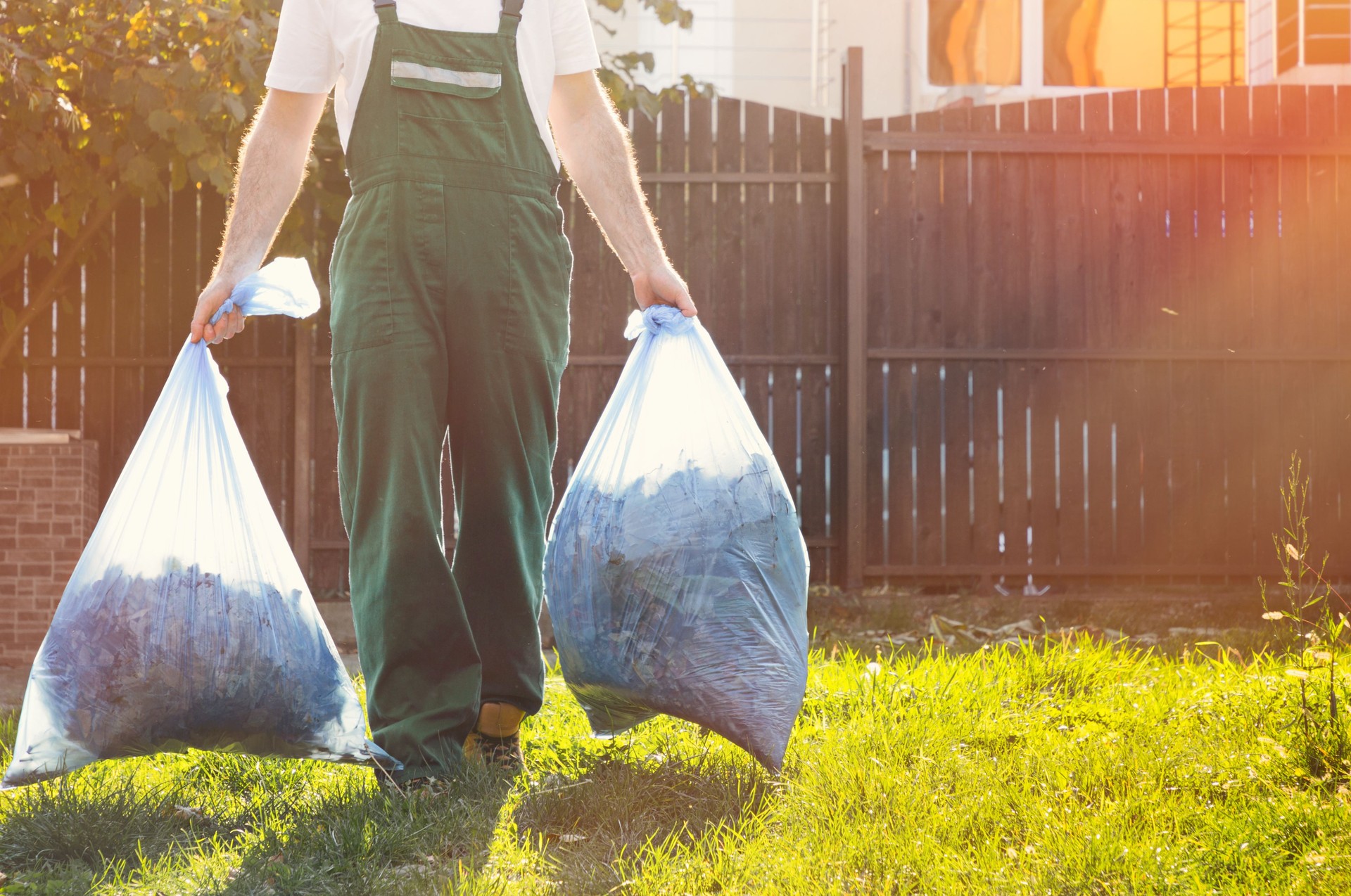 close-up of the gardener ,in the hands of bags of compost .sunlight on the right