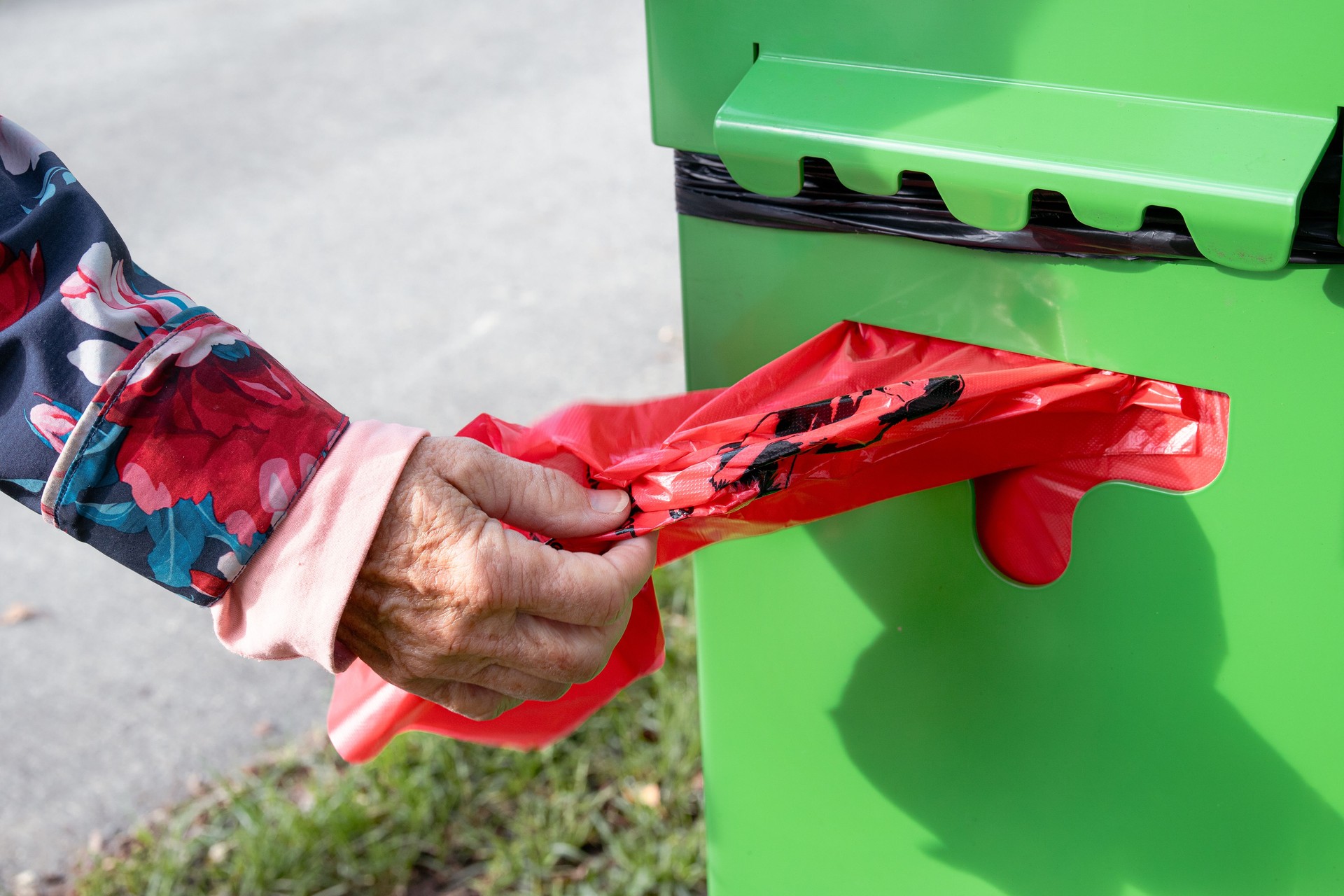 Person taking using public dog poop bag dispenser.